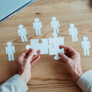 Puzzle pieces and paper people cutouts - Matching people with tasks